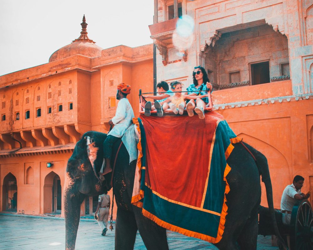 Tourists enjoying an elephant ride at Amber Fort in Jaipur, capturing vibrant Indian architecture and culture.